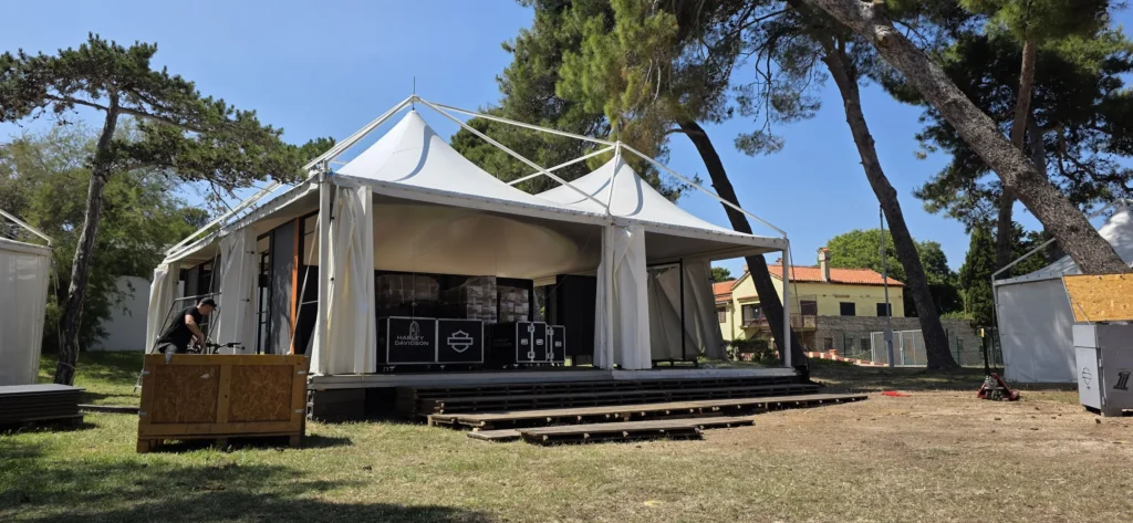 Pozornica s krovom od pagode i DJ pultom u borovom parku